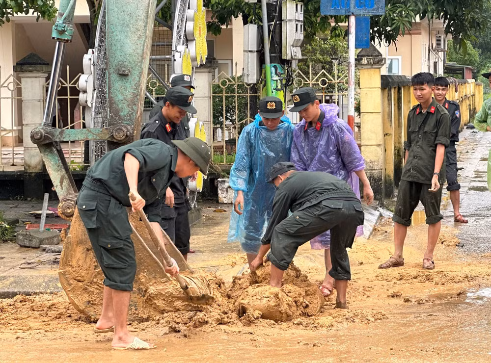 Cán bộ, chiến sĩ Phòng Cảnh sát cơ động Công an tỉnh Phú Thọ giúp người dân dọn dẹp đường xá.