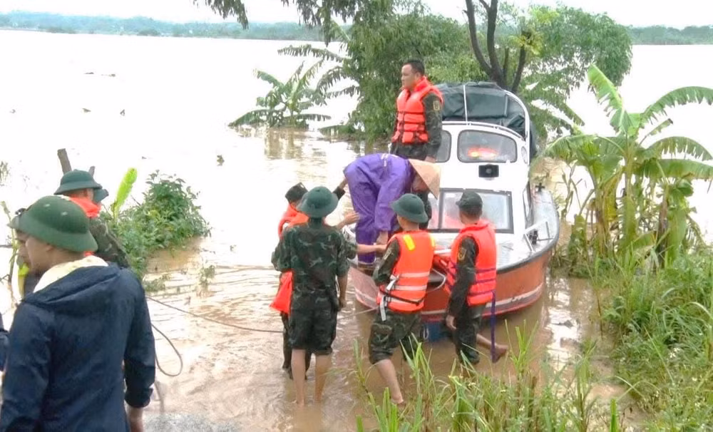 Các đơn vị vũ trang di dời người dân khu vực bãi bồi Phú Động vào nơi an toàn.