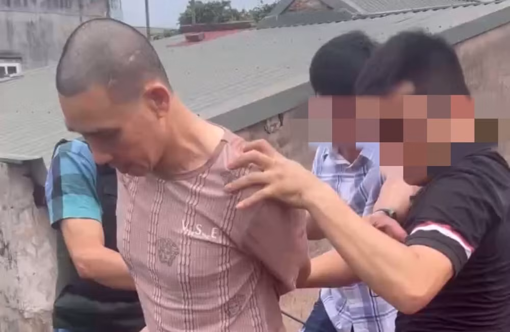 Lực lượng công an bắt giữ đối tượng Ngô Văn Đô trên mái nhà.