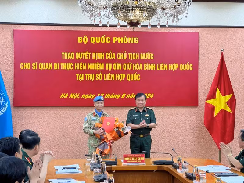 Thượng tướng Hoàng Xuân Chiến trao Quyết định của Chủ tịch nước và tặng hoa chúc mừng Thượng tá Trương Anh Tuấn đi thực hiện nhiệm vụ tại Trụ sở Liên hợp quốc.