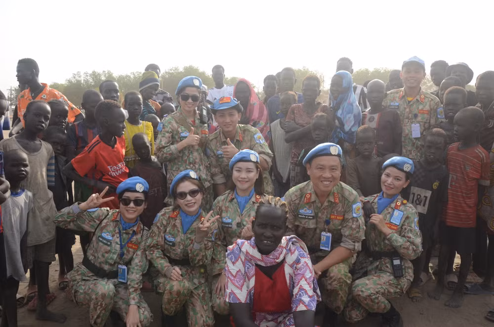 Các bác sĩ "mũ nồi xanh" Bệnh viện dã chiến cấp 2, số 5 của Việt Nam chụp ảnh cùng người dân tại Bentiu, bang Unity, Nam Sudan, tham dự Lễ mít-tinh kết hợp tuần hành, do Liên hợp quốc tổ chức, nhân Ngày Quốc tế Phụ nữ 8/3. Ảnh: Bệnh viện dã chiến cấp 2, số 5 cung cấp.