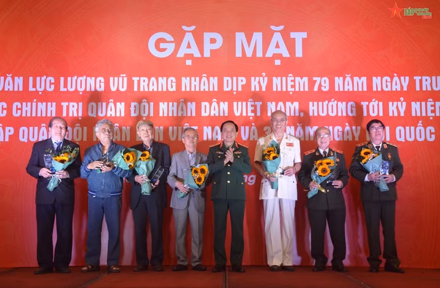 Thượng tướng Trịnh Văn Quyết trao biểu trưng và hoa tặng các nhà văn lực lượng vũ trang tiêu biểu. (Ảnh: Báo Quân đội nhân dân)