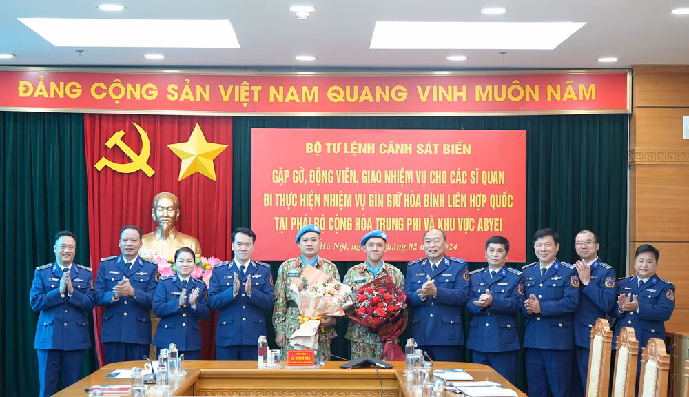 Các đại biểu chụp ảnh lưu niệm với hai cán bộ đi thực hiện nhiệm vụ gìn giữ hòa bình Liên hợp quốc.