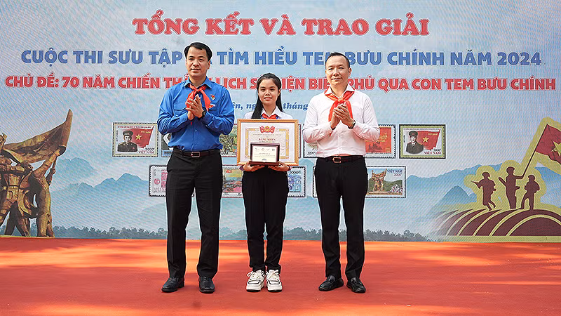 Bí thư Trung ương Đoàn Ngô Văn Cương (bên trái) và đại diện Ban tổ chức Cuộc thi trao giải đặc biệt tặng thí sinh Đặng Lê Gia Nhi.