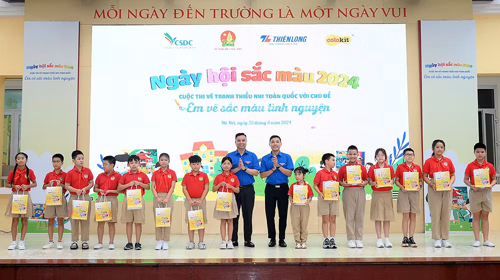 Đồng chí Lê Anh Quân (áo xanh, bên trái) và đại diện các đơn vị liên quan trao quà tặng học sinh có thành tích tốt.