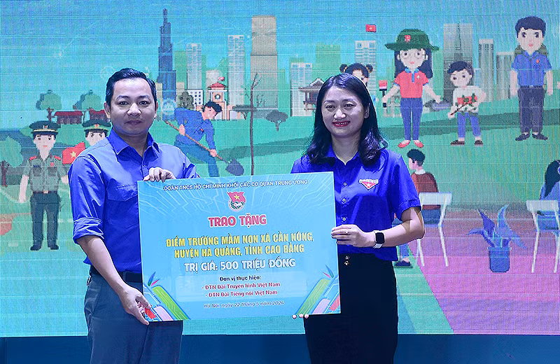 Đại diện Đoàn Thanh niên Đài Truyền hình Việt Nam (bên trái) trao tượng trưng công trình xây dựng điểm trường tại buổi lễ.