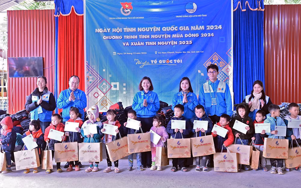 Giám đốc Trung tâm Tình nguyện quốc gia Đỗ Thị Kim Hoa và đại diện các đơn vị liên quan trao quà tặng thiếu nhi có hoàn cảnh khó khăn ở địa phương.