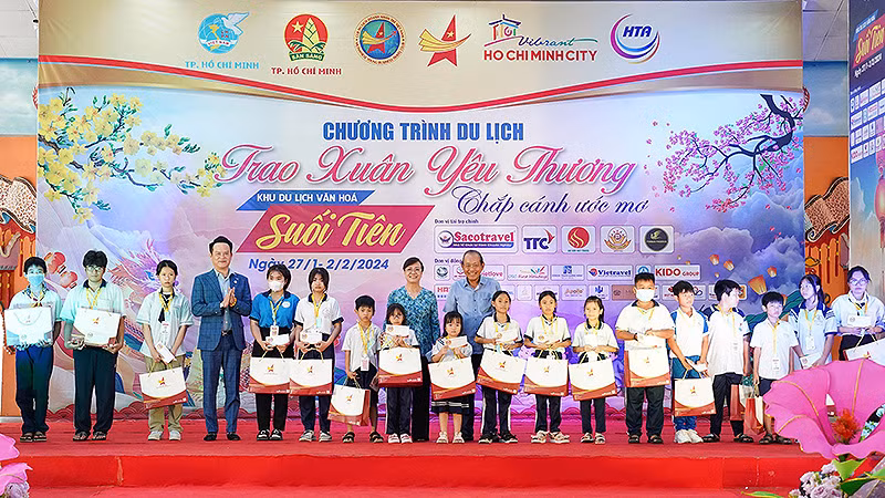 Nguyên Phó Thủ tướng Thường trực Trương Hòa Bình (bên phải, hàng thứ hai) và Chủ tịch Hội Doanh nhân trẻ Việt Nam Đặng Hồng Anh (thứ 4 từ trái sang) trao quà tặng các em nhỏ có hoàn cảnh khó khăn.