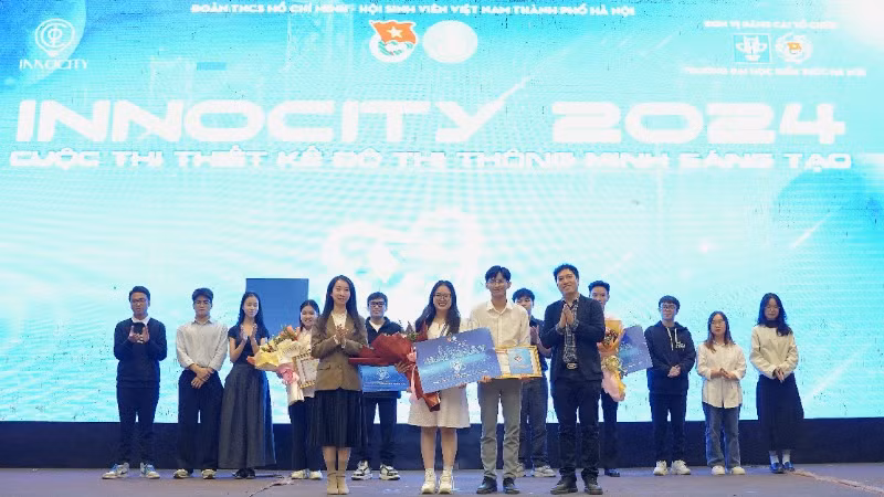 Phó Chủ tịch Hội Sinh viên Hà Nội Vũ Thị Minh Hằng (bên trái) và đại diện các đơn vị trao giải Nhất tặng thành viên đội Awake Drive - Vững bước trên đường dài (Đại học Bách khoa Hà Nội). 