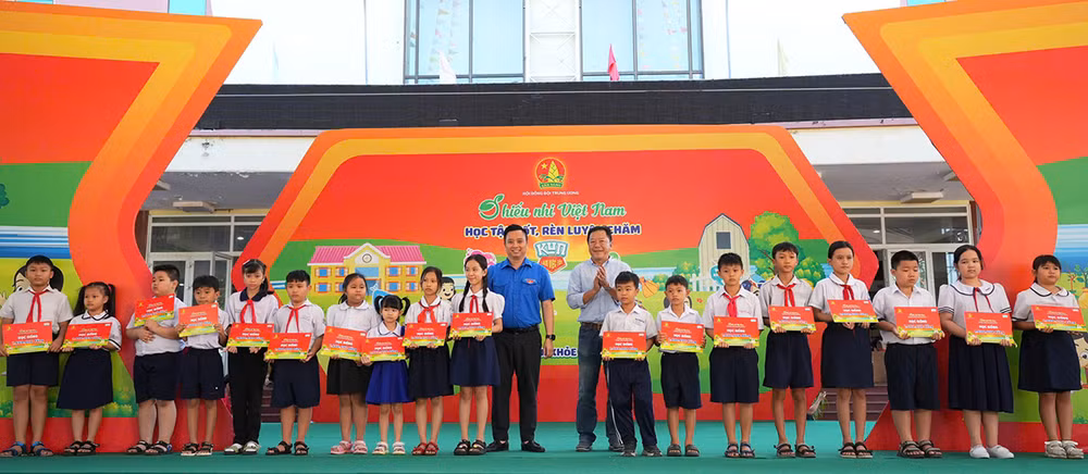 Đồng chí Lê Anh Quân (áo xanh) cùng đại diện lãnh đạo địa phương trao học bổng "Tiếp sức cho em đến trường" tặng thiếu nhi vượt khó học tốt.