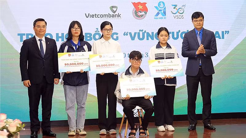 Đồng chí Bùi Quang Huy, Ủy viên dự khuyết Trung ương Đảng, Bí thư thứ nhất Trung ương Đoàn và ông Nguyễn Thanh Tùng, Tổng Giám đốc Vietcombank (lần lượt ngoài cùng bên phải và trái) trao học bổng "Vững bước tương lai" loại A tặng học sinh, sinh viên xuất sắc.