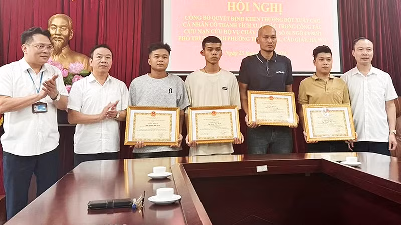 Đồng Văn Tuấn và Hoàng Anh Tuấn (thứ 4 và 5 từ phải sang) cùng các cá nhân tiêu biểu nhận Bằng khen của Ủy ban nhân dân quận Cầu Giấy sau vụ cháy ở phố Trung Kính.