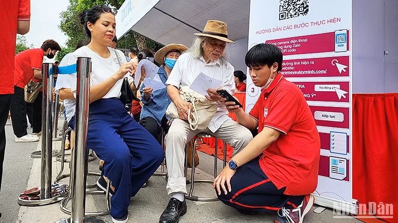 Các tình nguyện viên hỗ trợ người dân khám sàng lọc trong khuôn khổ Lễ ra quân Hành trình. 