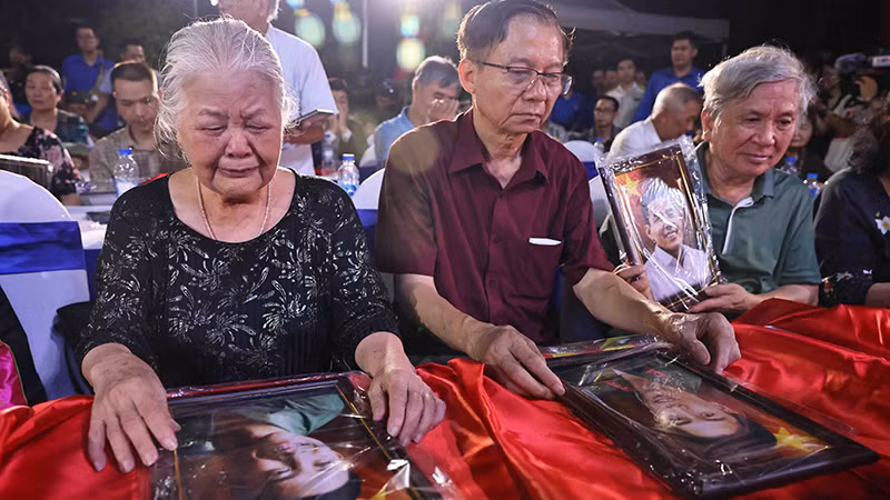 Đại diện gia đình các liệt sĩ nhận di ảnh phục dựng tại buổi lễ.