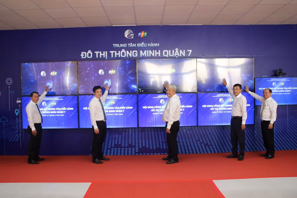 Ông Võ Khắc Thái - Bí Thư Quận ủy Quận 7 (thứ 3 từ trái sang), ông Nguyễn Văn Khoa - Tổng Giám đốc Tập đoàn FPT (thứ 2 từ trái sang) cùng đại diện lãnh đạo Quận 7 nhấn nút khai trương Trung tâm điều hành đô thị thông minh.
