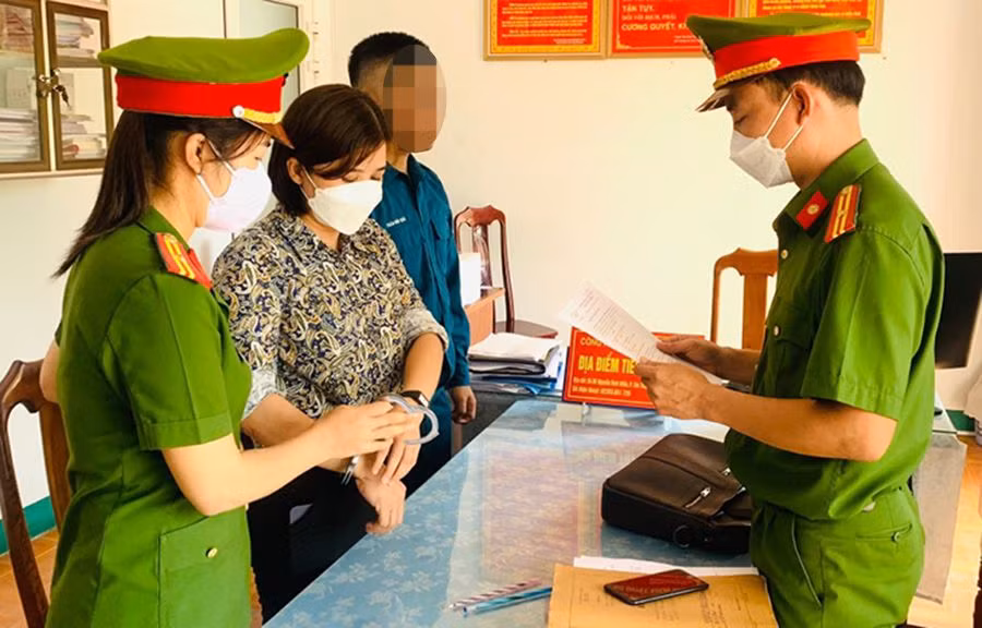 Công an tống đạt quyết định khởi tố bị can, bắt tạm giam Trần Thị Hồng. (Ảnh Công an cung cấp)