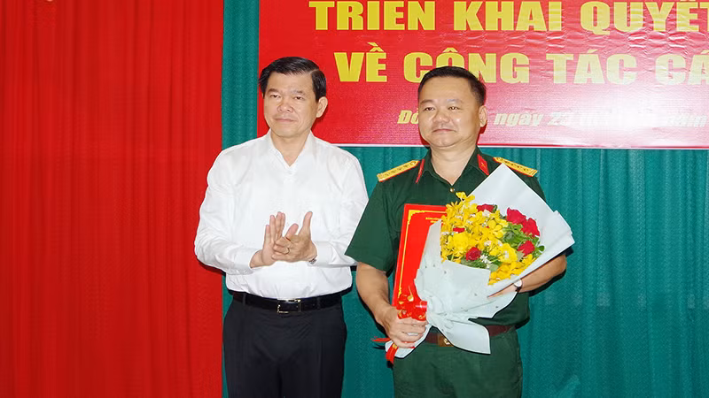 Đồng chí Nguyễn Hồng Lĩnh, Ủy viên Trung ương Đảng, Bí thư Tỉnh ủy, Bí thư Đảng ủy Quân sự tỉnh Đồng Nai trao quyết định và tặng hoa chúc mừng Đại tá Bùi Đăng Ninh.