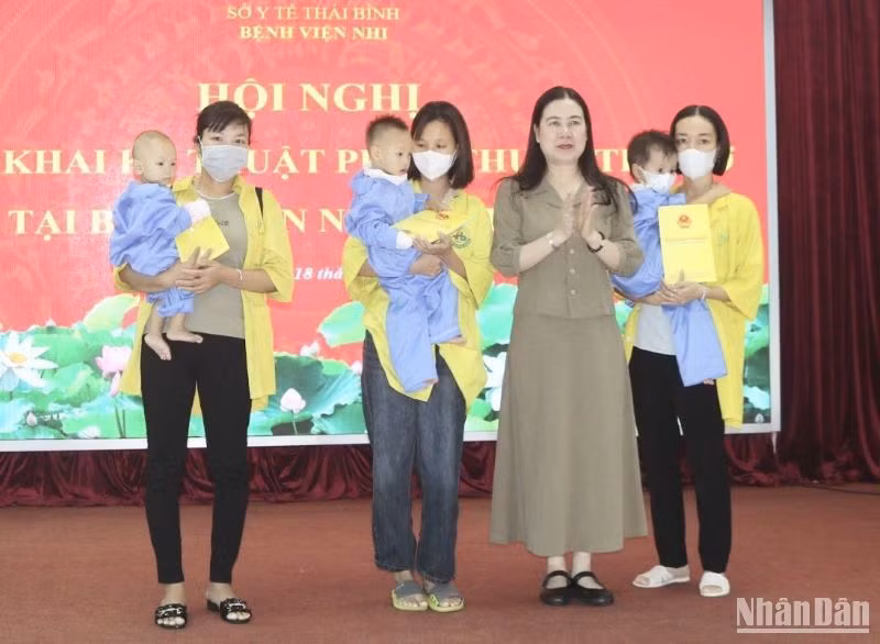 Phó Chủ tịch Ủy ban nhân dân tỉnh Thái Bình Trần Thị Bích Hằng trao hỗ trợ kinh phí cho 3 trẻ em được phẫu thuật tim hở dịp này.