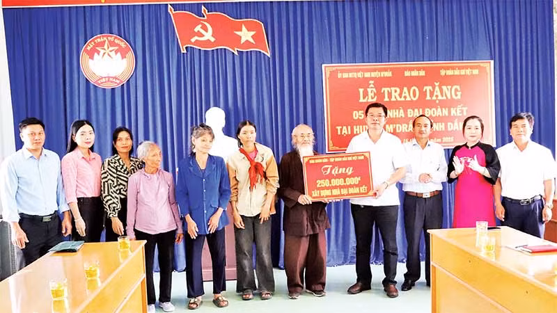 Đại diện Báo Nhân Dân trao bảng tượng trưng số tiền 250 triệu đồng tặng 5 gia đình ở huyện M’Drắk xây nhà Đại đoàn kết.