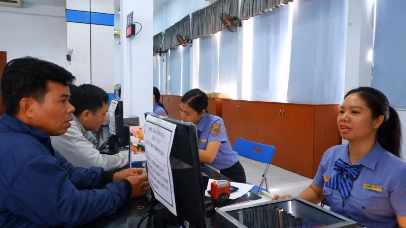 Hành khách đến ga Sài Gòn thanh toán lấy vé tàu Tết.