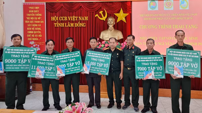 Ban tổ chức trao bảng tượng trưng cho Hội Cựu chiến binh các địa phương tỉnh Lâm Đồng tặng tập vở cho học sinh địa phương.