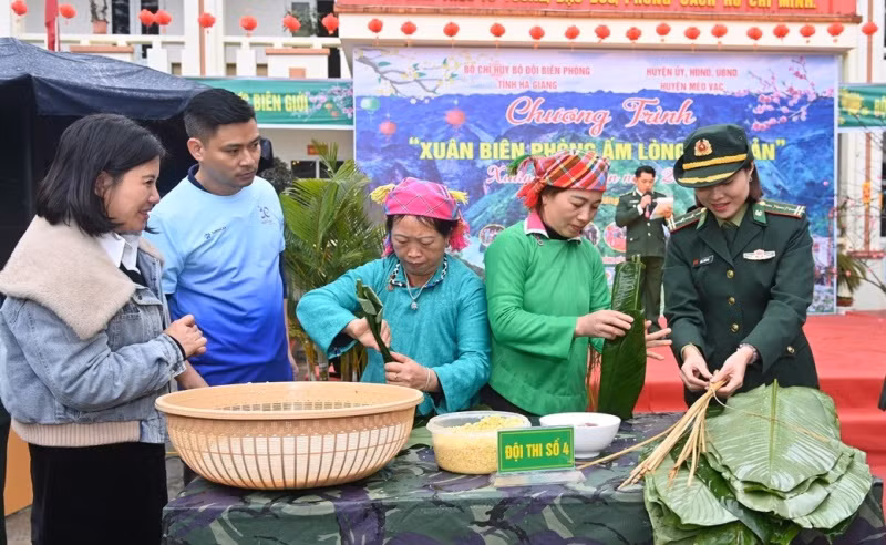Cán bộ, chiến sĩ Bộ đội Biên phòng tỉnh Hà Giang cùng người dân xã biên giới Sơn Vĩ, huyện Mèo Vạc cùng gói bánh chưng trong Chương trình “Xuân Biên phòng ấm lòng dân bản”. Ảnh: Khánh Toản