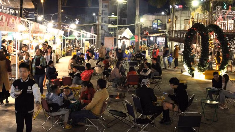 Bàn ghế đông đúc người ăn uống.