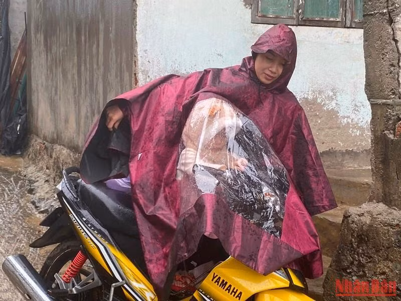 Mẹ con chị Nguyễn Thị Thu ở thôn Phước Thiện, xã Bình Hải di chuyển lên khu vực tạm lánh của xã để tránh bão Noru.