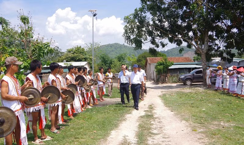 Bà con Rơ Măm tại làng Le, xã Mô Rai, huyện Sa Thầy đón đồng chí Dương Văn Trang (đi đầu) và đoàn công tác đến làm việc với làng.