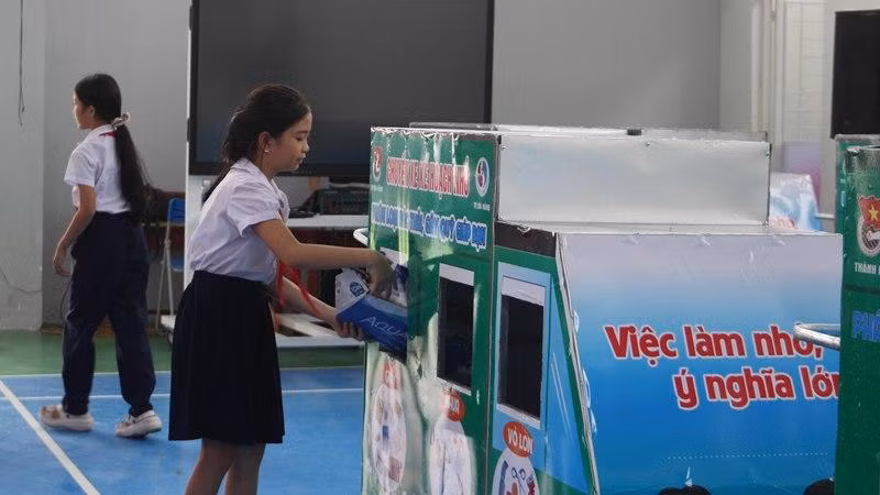 Học sinh bỏ rác vào chuyến xe.