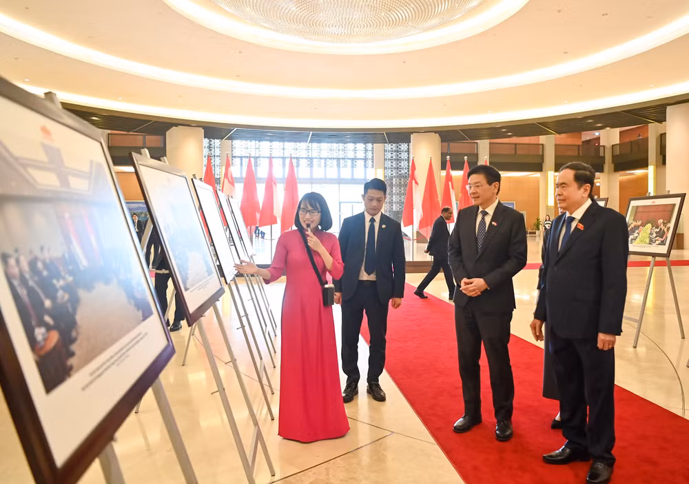 Chủ tịch Quốc hội Trần Thanh Mẫn và Thủ tướng Singapore Lawrence Wong xem trưng bày ảnh về quan hệ Việt Nam-Singapore. (Ảnh Duy Linh)