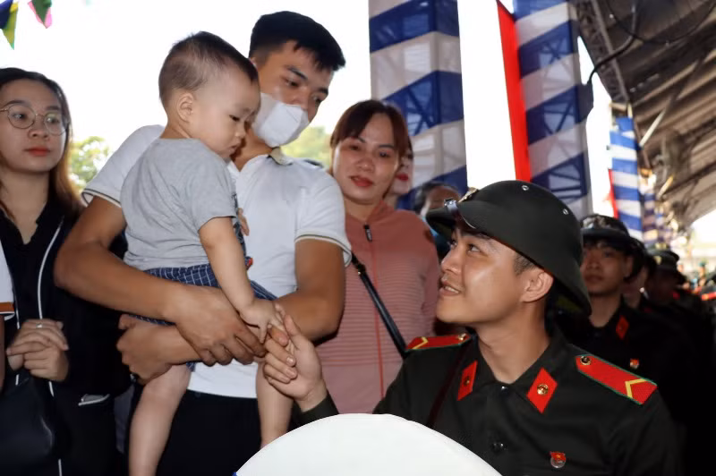Gia đình và con trai 19 tháng tuổi đến tiễn tân binh Phan Quốc Tuấn lên đường tham gia nghĩa vụ Công an nhân dân tại điểm giao nhận quân thành phố Biên Hòa.