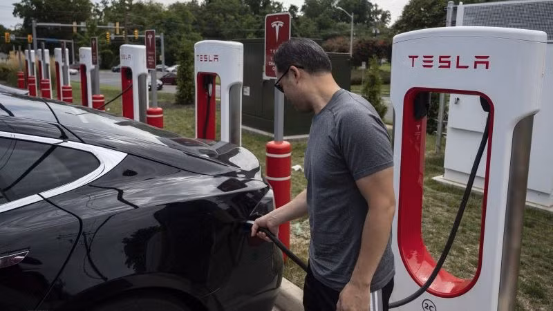 Người dân sạc điện cho ô-tô tại một trạm sạc của Tesla ở Arlington, Virginia, Mỹ. (Ảnh: AFP/TTXVN)