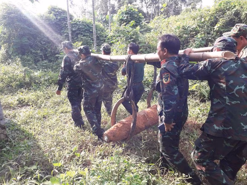 Lực lượng chức năng di chuyển quả bom đến vị trí hủy nổ. (Ảnh: MINH ĐỨC)