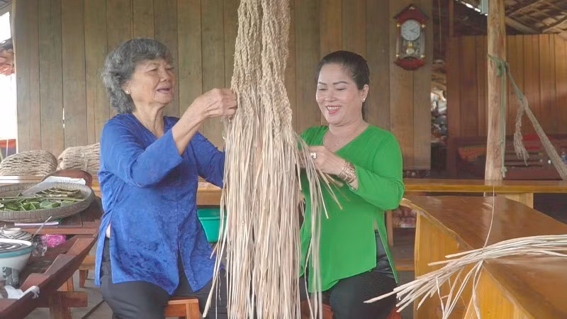 Bà Bàn Thị Xiếu đang hướng dẫn khách đan võng dây chuối.