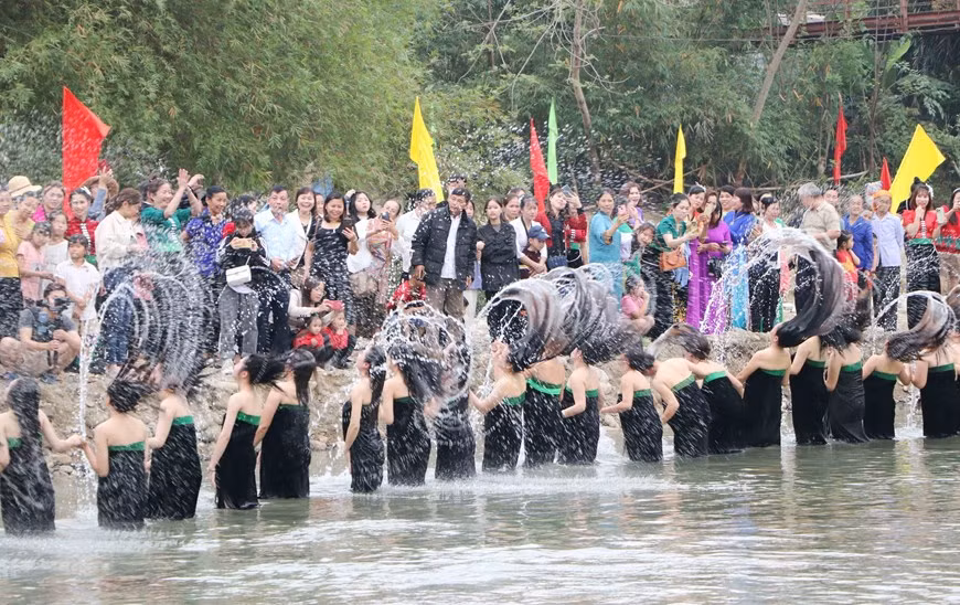 Màn hất tóc ấn tượng của các cô gái Thái tại lễ hội gội đầu. (Ảnh: Văn Oanh/TTXVN)