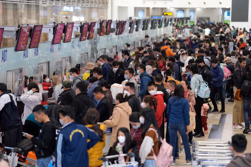 Hành khách làm thủ tục hàng không tại Nhà ga T1 Cảng hàng không quốc tế Nội Bài giờ cao điểm sáng 29/1. 