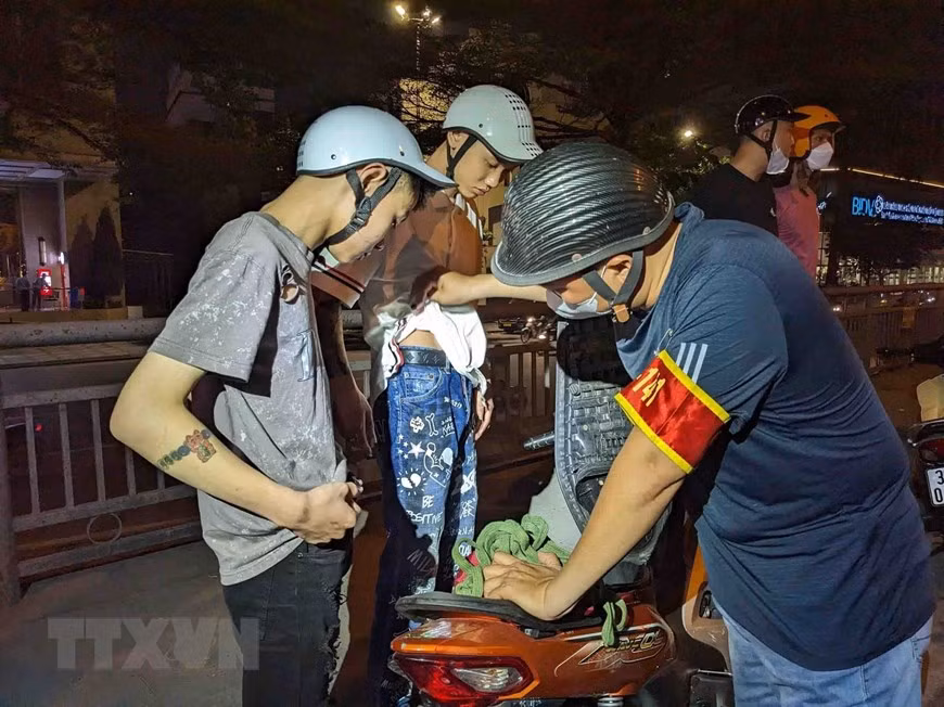 Tổ công tác Y9/141 hóa trang kiểm tra và bắt giữ 1 trường hợp đi xe máy điều khiển xe chạy tốc độ cao, lạng lách đánh võng, nẹt pô, gây mất trật tự công cộng. (Ảnh: Phạm Kiên/TTXVN)