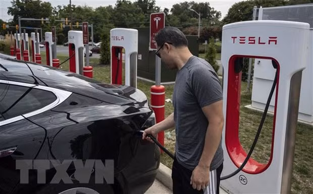 Người dân sạc điện cho ô-tô tại một trạm sạc của Tesla ở Arlington, Virginia, Mỹ. (Ảnh: AFP/TTXVN)