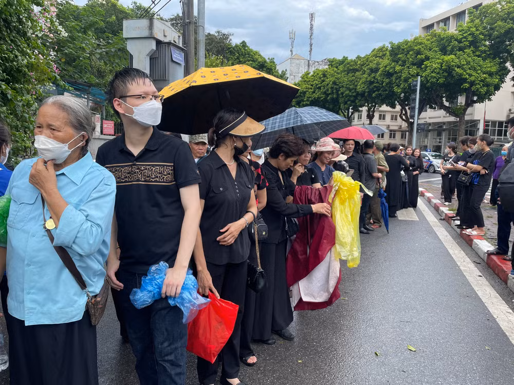 Đầu giờ chiều, sau cơn mưa lớn, người dân chờ đợi bên ngoài phố Trần Thánh Tông để vào viếng Tổng Bí thư.