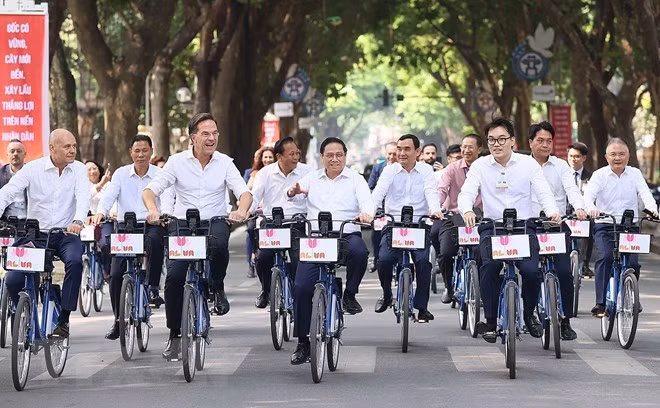 Thủ tướng Phạm Minh Chính và Thủ tướng Hà Lan Mark Rutte đạp xe tham quan không gian của Thủ đô. (Ảnh: Dương Giang/TTXVN)