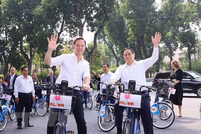 Thủ tướng Phạm Minh Chính và Thủ tướng Hà Lan Mark Rutte trên phố Hà Nội. (Ảnh: Dương Giang/TTXVN)