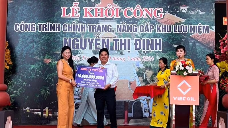 Đại diện nhà tài trợ trao bảng tượng trưng xây dựng công trình chỉnh trang, nâng cấp Khu lưu niệm Nguyễn Thị Định. 