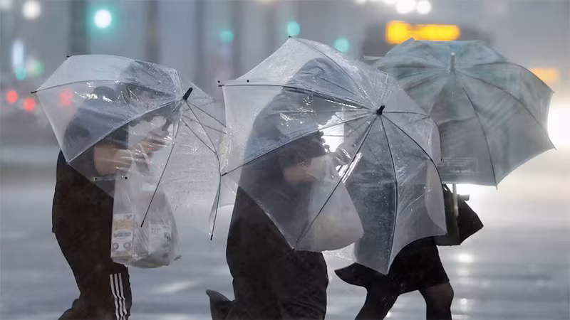 Người dân di chuyển trong thời tiết có mưa lớn và gió mạnh tại Kagoshima, ngày 28/8/2024. (Ảnh: Reuters)