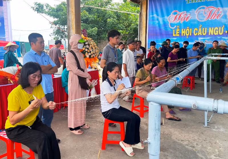 Các phụ nữ vùng duyên hải Sầm Sơn thi đan lưới.