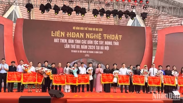 Đại diện ban tổ chức tặng hoa và cờ cho các đoàn tham dự liên hoan.