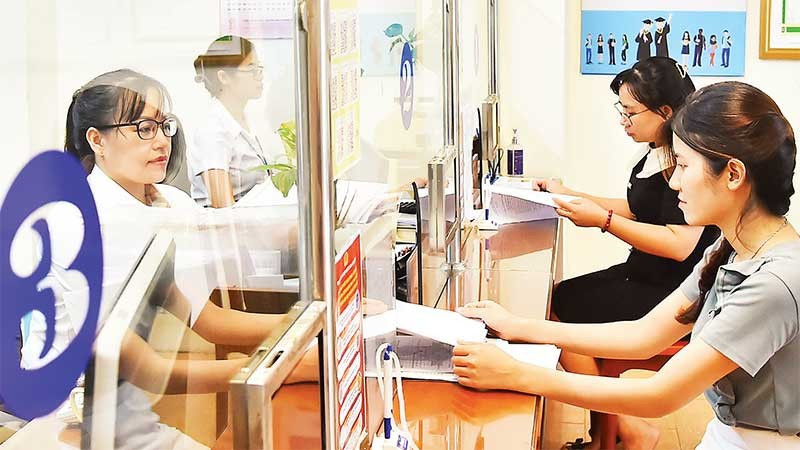 Cán bộ Bộ phận một cửa phường Thanh Xuân Nam, quận Thanh Xuân giải quyết thủ tục hành chính cho người dân. (Ảnh MỸ HÀ)