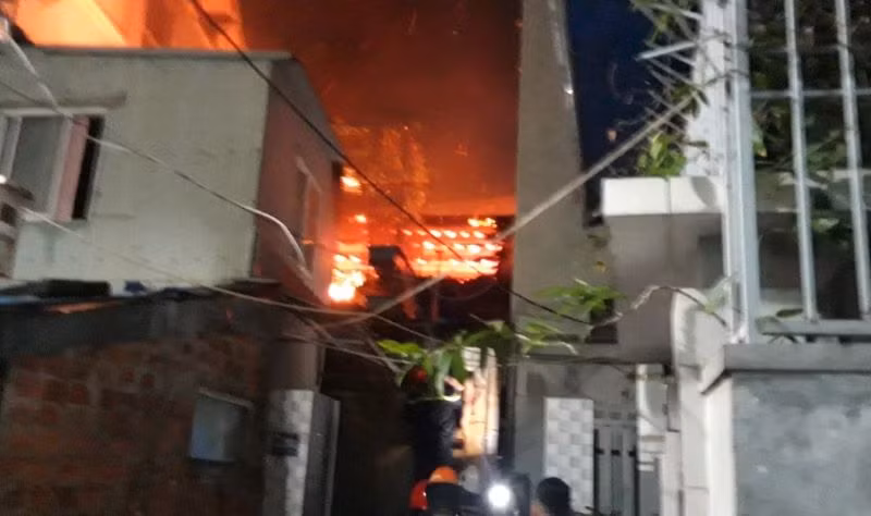 Lực lượng cảnh sát phòng cháy chữa cháy đục tường cứu sống các nạn nhân. (Ảnh: Công an cung cấp)