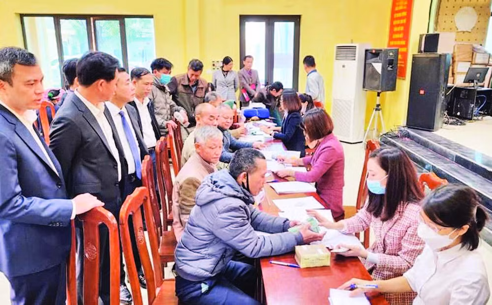 Chi trả tiền hỗ trợ bồi thường giải phóng mặt bằng cho các hộ gia đình có đất nằm trong chỉ giới thu hồi phục vụ dự án đường vành đai 4 - Vùng Thủ đô tại xã Song Phương, huyện Hoài Đức. (Ảnh: TRẦN THỤ)