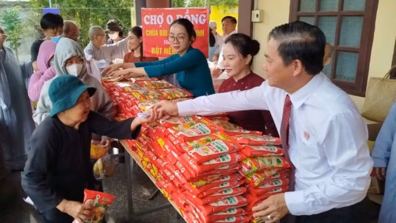 Chủ tịch Hội đồng nhân dân tỉnh Bình Dương Nguyễn Văn Lộc và đại diện các đơn vị trao hàng hóa tại "Chợ 0 đồng" cho người dân có hoàn cảnh khó khăn.
